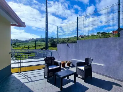 a balcony with two chairs and a table and a fence at Santana Madeira Hiking Getaway near Pico Ruivo and Levadas Base in Santana