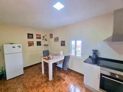 a kitchen with a table with two chairs and a refrigerator at Santana Madeira Hiking Getaway near Pico Ruivo and Levadas Base in Santana