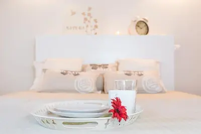 a tray with plates and a candle on a bed at Villa T3 com Jardim Vila Sagres M8 in Sagres