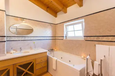 a bathroom with a tub and a sink and a mirror at Villa T3 com Jardim Vila Sagres M8 in Sagres