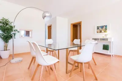 a dining room with a glass table and white chairs at Villa T3 com Jardim Vila Sagres M8 in Sagres