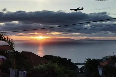 an airplane flying over the ocean at sunset at Mazelia's House in Gaula