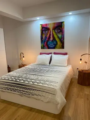 a bedroom with a large bed with a painting on the wall at Mazelia's House in Gaula
