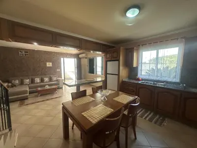 a kitchen with a wooden table and a staircase at The House of Passos in Ponta do Sol