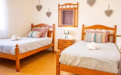 a bedroom with two beds and a window with hearts on the wall at Casa Bellarosa in Raposeira