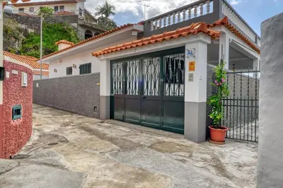 a garage with a black gate and a fence at Villa Rosa, a Home in Madeira in Funchal
