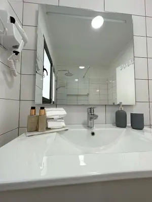 a white bathroom with a sink and a mirror at Madeiran Sweet Home in Funchal