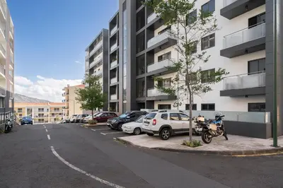 a parking lot with cars parked next to a building at Barreiros IV by An Island Apart in Funchal