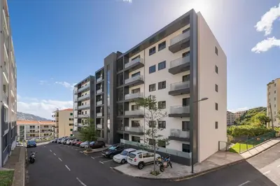 an apartment building with cars parked in a parking lot at Barreiros IV by An Island Apart in Funchal