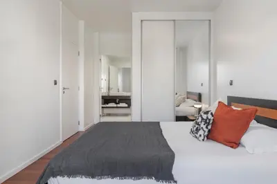 a bedroom with a large white bed with orange pillows at Barreiros IV by An Island Apart in Funchal