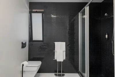 a black and white bathroom with a toilet and a shower at Barreiros IV by An Island Apart in Funchal