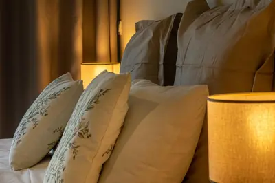 a group of pillows on a bed with a lamp at Ocean view and Infinity pool Apartment in Funchal