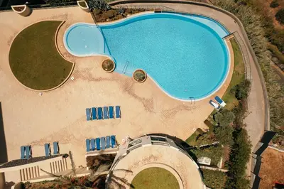 an overhead view of a large swimming pool with chairs at Ocean view and Infinity pool Apartment in Funchal