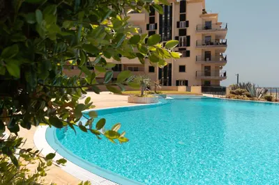 a large swimming pool next to a tall building at Ocean view and Infinity pool Apartment in Funchal