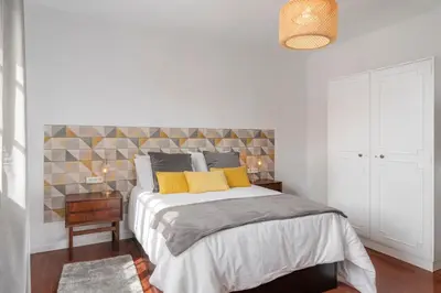 a bedroom with a large bed with yellow pillows at OurMadeira - BelleVeva in Funchal