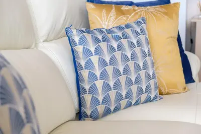 a white couch with blue and white pillows on it at GuestReady - Tranquil Nest in Funchal in Funchal