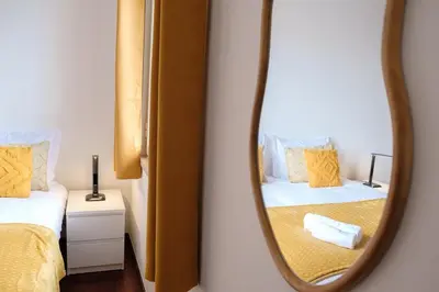 a mirror reflection of a bedroom with two beds at GuestReady - Tranquil Nest in Funchal in Funchal