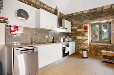 a white kitchen with white cabinets and appliances at Quinta Alcaparras in Porto Santo