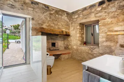 a stone house with a patio with a table and chairs at Quinta Alcaparras in Porto Santo