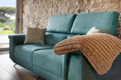 a blue couch in a living room with a wall at Quinta Alcaparras in Porto Santo