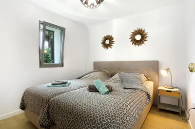 a bedroom with a bed and two mirrors on the wall at Casa De Pedra in Porto Santo