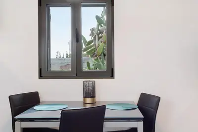 a dining room table with two chairs and a window at Casa Do Vinho in Porto Santo
