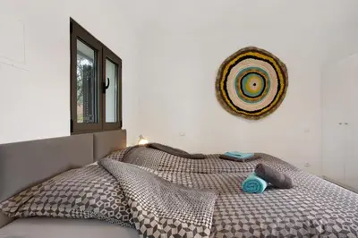 a bedroom with a bed with a comforter and a window at Casa Do Vinho in Porto Santo