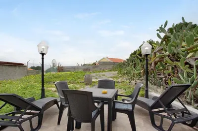 a group of chairs and a table on a patio at Casa Do Vinho in Porto Santo