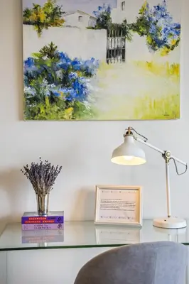 a desk with a lamp and a painting on the wall at Lavender - By Wehost in Funchal