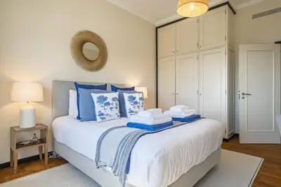 a bedroom with a bed with blue pillows and a mirror at Lavender - By Wehost in Funchal