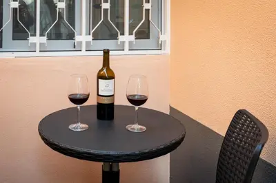 a bottle of wine and two glasses on a table at Fisherman's house in Porto Moniz
