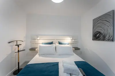a bedroom with a bed with blue and white pillows at Fisherman's house in Porto Moniz