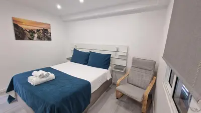 a bedroom with a bed and a chair at Ocean Breeze in Porto Moniz