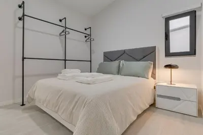 a white bedroom with a bed with towels on it at Graça House in Machico