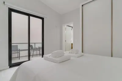 a white bed with two pillows on top of it at Graça House in Machico