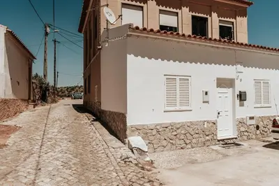 a cobblestone street next to a white building at Charming traditional house in tiny, cozy village in Vale de Boi