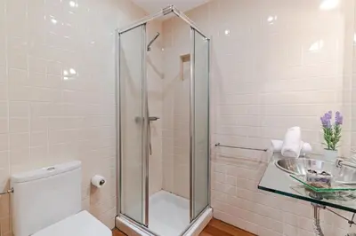 a bathroom with a shower and a toilet and a sink at Villa Sol e Mar by Villa Plus in Caniço