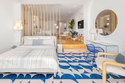 a bedroom with a bed and a blue and white floor at Ocean Studio by ENDLESS SUN I modern comfort, sea view, wi-fi, parking, rooftop pool in Lagos