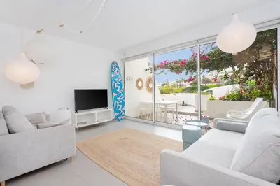 a living room with white furniture and a large window at Ocean Studio by ENDLESS SUN I modern comfort, sea view, wi-fi, parking, rooftop pool in Lagos