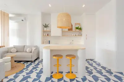 a living room with a kitchen with a counter and stools at Ocean Studio by ENDLESS SUN I modern comfort, sea view, wi-fi, parking, rooftop pool in Lagos