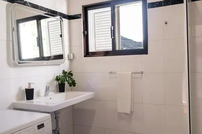 a white bathroom with a sink and a shower at GuestReady - Machico sea view residence - B in Machico