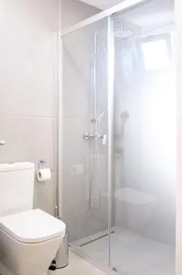 a white bathroom with a shower and a toilet at GuestReady - Machico sea view residence - B in Machico