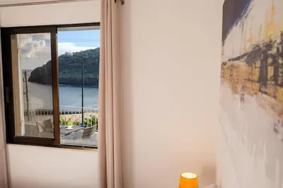 a window in a room with a view of the ocean at GuestReady - Machico sea view residence - B in Machico