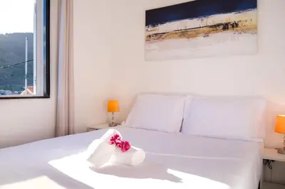 a bedroom with a white bed with a pink flower on it at GuestReady - Machico sea view residence - B in Machico