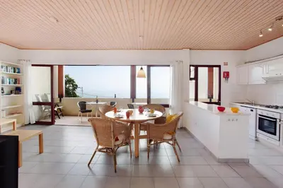 a living room with a red couch and a table at Casa Conny in Caniço