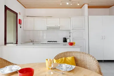 a white kitchen with a stove and a refrigerator at Casa Conny in Caniço