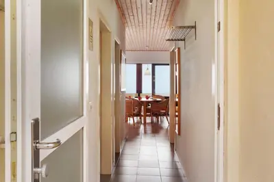a kitchen with white cabinets and a wooden table at Casa Conny in Caniço
