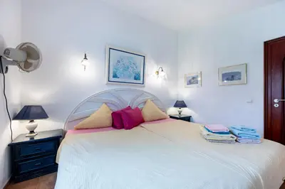 a bedroom with a large white bed with pink pillows at Seaside Retreat Casa Romana in Luz