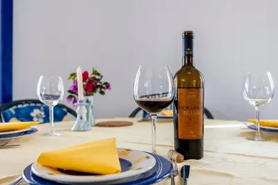 a bottle of wine sitting on a table with a glass at Seaside Retreat Casa Romana in Luz