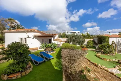 a garden with lawn chairs and a house at Seaside Retreat Casa Romana in Luz